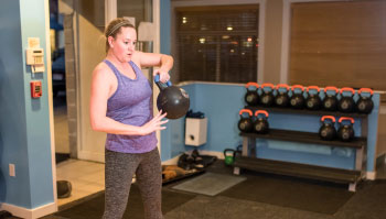 woman exercising with kettlebell in gym